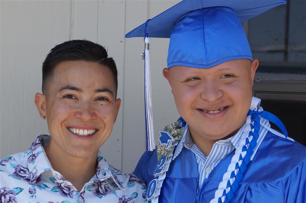 Female teacher with male student at graduation ceremony