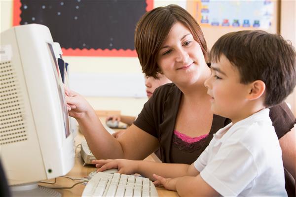 Teacher working with student at a computer