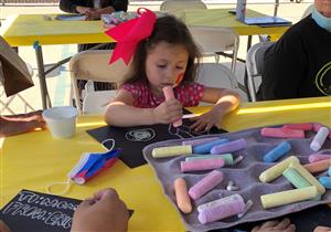 Little girl drawing with chalk