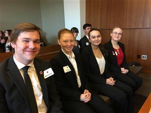 Four Mock Trial students sitting in the courtroom 